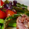 tomatoes, asparagus, and meat on a plate