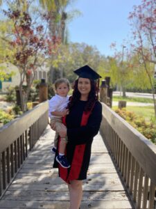 Jordan Jump in a graduation gown holding her child