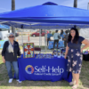 Self Help Credit Union Booth With two SDSU Faculty standing by it.